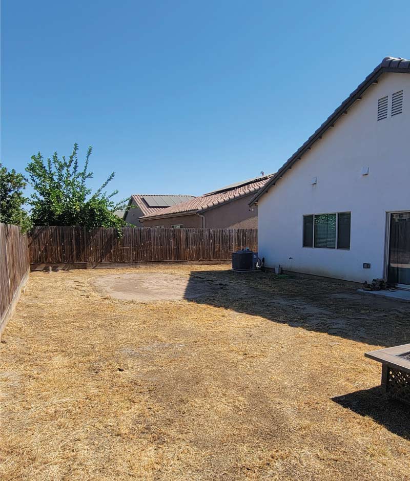 The same backyard, now completely cleared of all debris and the swimming pool, showcasing a successful property cleanout